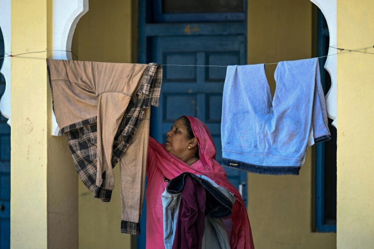 A displaced woman hangs clothes to dry at a Sikh temple in Jammu, a key city in Indian-administered Kashmir