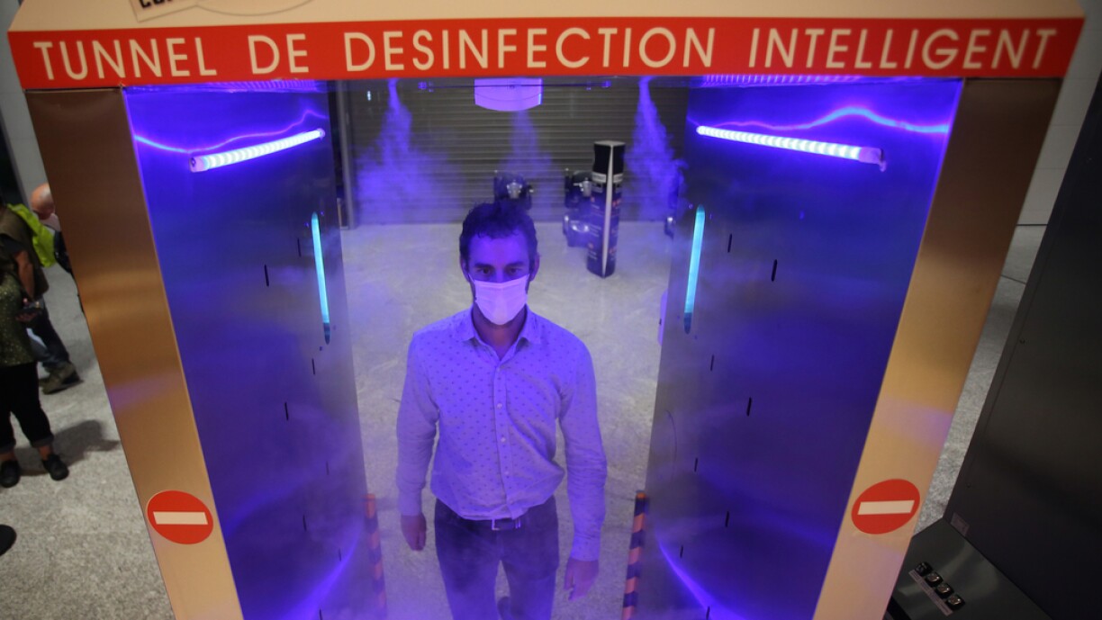 A man walks through a 'disinfection tunnel' as he enters the Leclerc Baleone supermarket in Ajaccio on November 9, 2020 on the French Mediterranean island of Corsica.