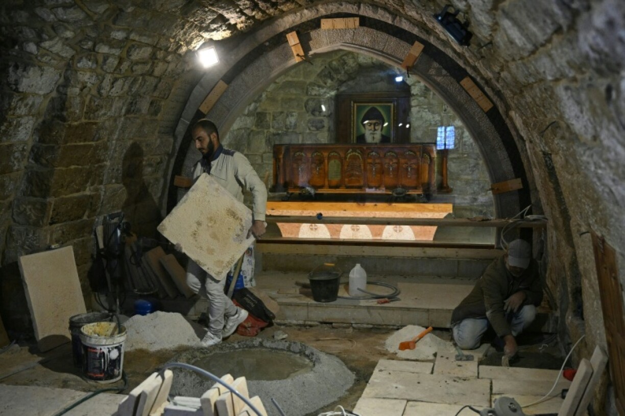 Workers renovate floor tiles at the shrine of Saint Charbel in the monastery