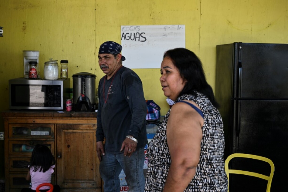Erik Payan and his wife Alejandrina Morales speak in their tire repair shop in Cleveland, Texas