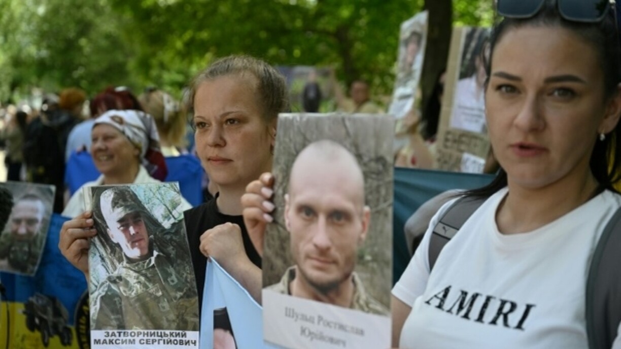 Des Ukrainiens brandissent des portraits de leurs parents captifs ou disparus dans l'espoir qu'ils seront reconnus par l'un ou l'autre des prisonniers de guerre libérés dans le cadre d'un échange avec la Russie, le 23 mai 2025