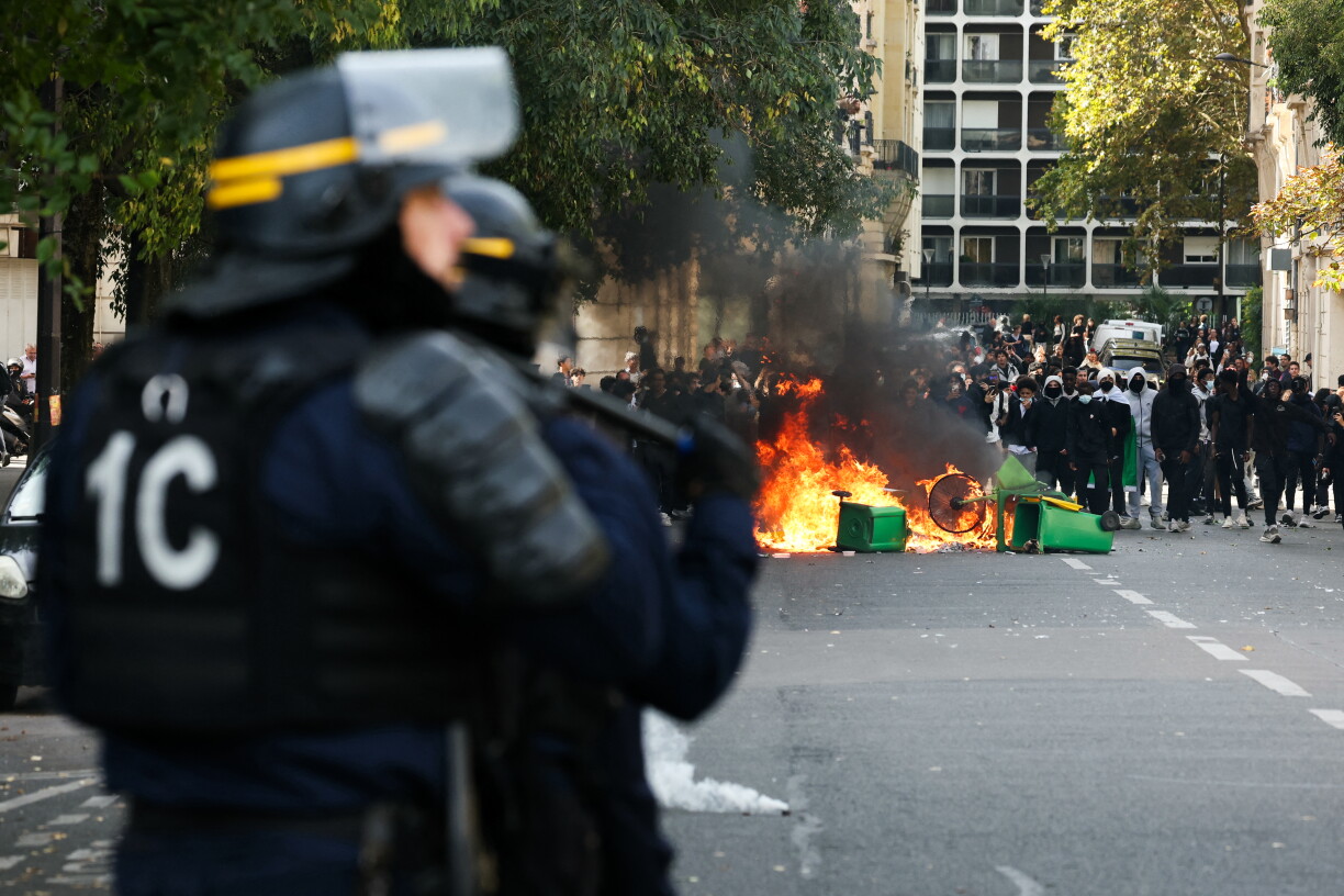 CRS riot police stand near a fire as protesting students carry out blockading action near place de la Nation, in Paris, on October 2, 2026.
