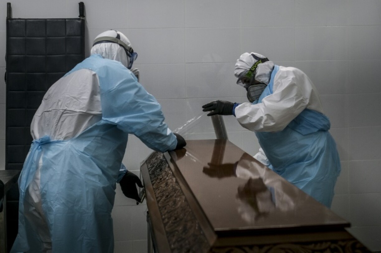 Des employés des pompes funèbres scellent le cercueil d'une victime du Covid-19 aux pompes funèbres à Amadora, dans la banlieue de Lisbonne, le 29 janvier 2021