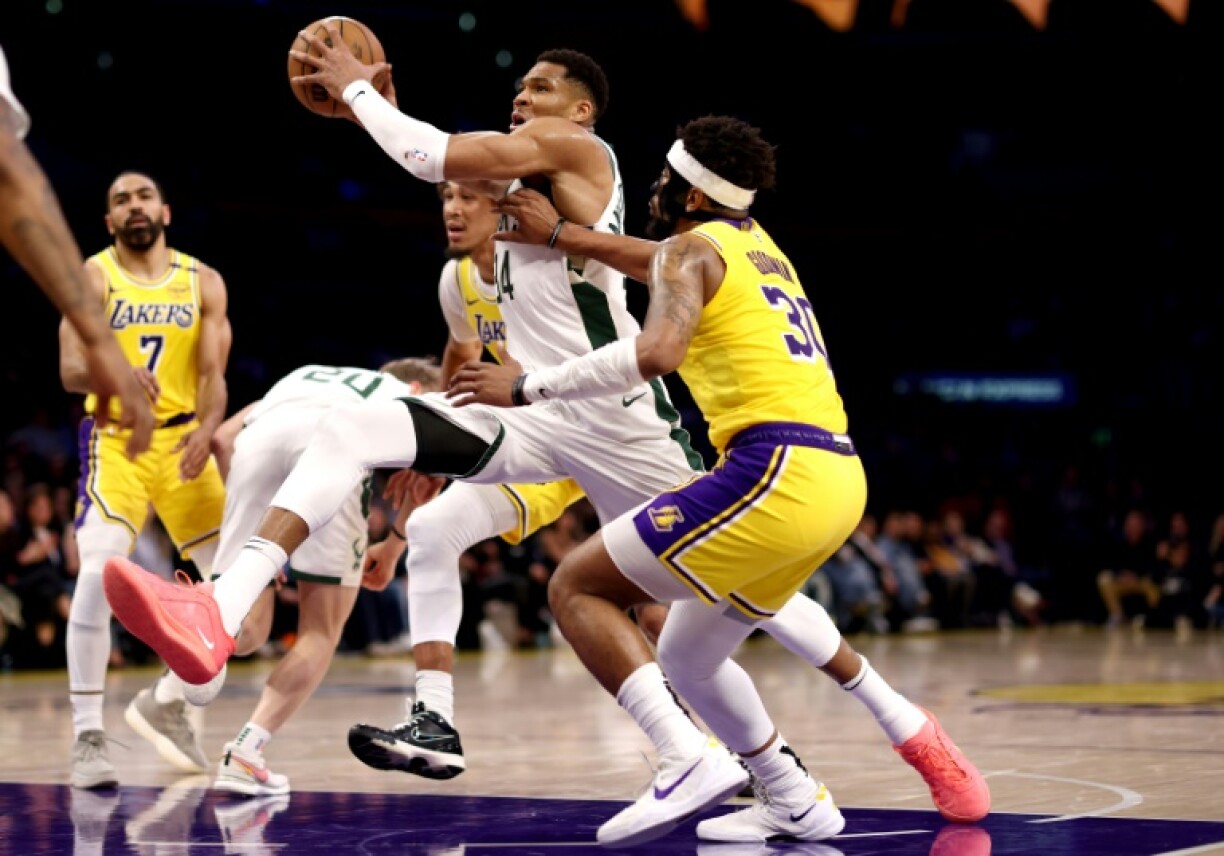 Milwaukee star Giannis Antetokounmpo drives to the basket against Jordan Goodwin and Jaxson Hayes in the Bucks' NBA victory over the Los Angeles Lakers