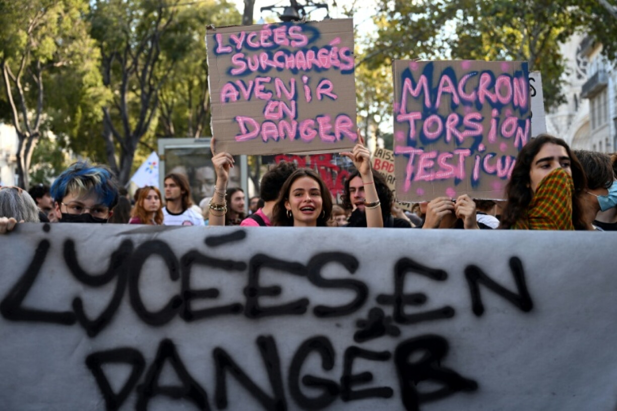 A student holds a placard reading 'overcrowded high schools, future in danger'