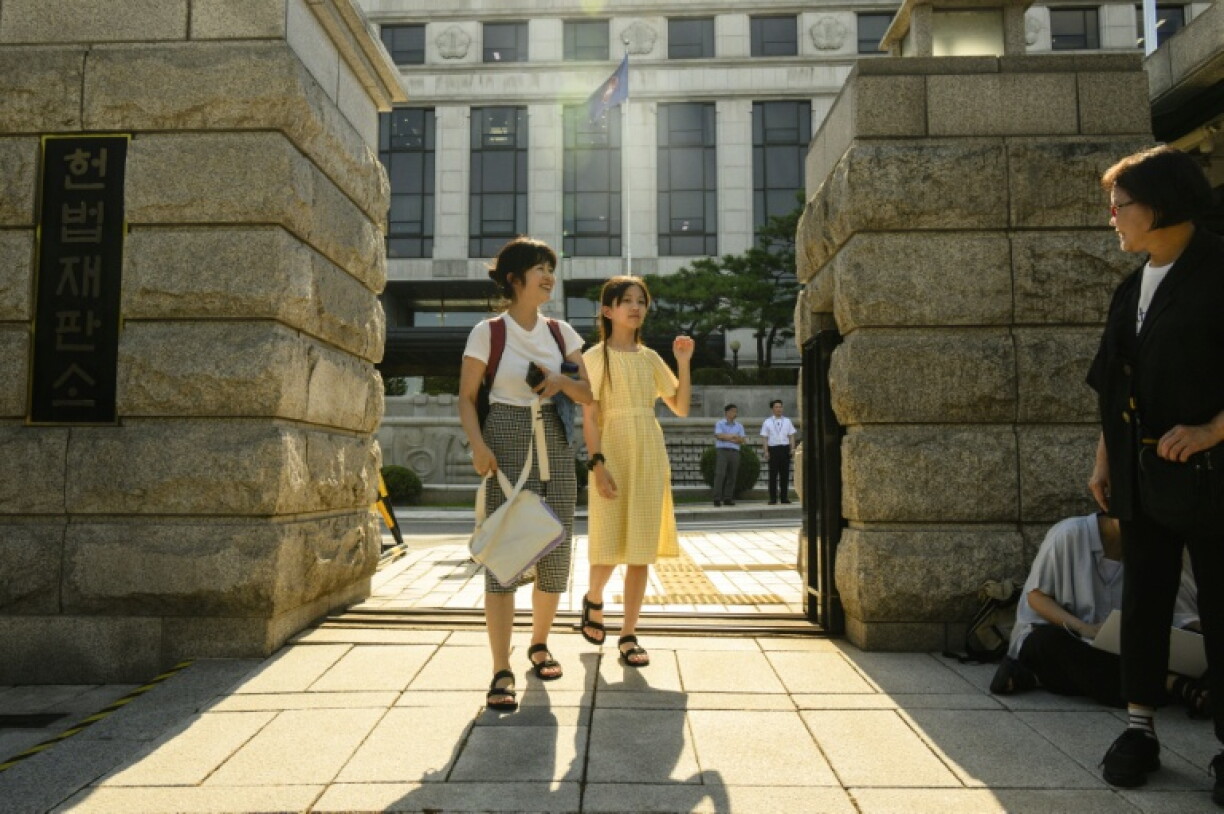 Young climate activist Han Jeah and her mother, Kim Eun-jae, celebrate outside South Korea's Constitutional Court after their victory in August 2024, which forced the government to set new targets for reducing greenhouse gas emissions