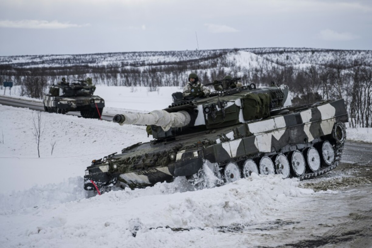 Finnish soldiers ride a Leopard 2 German main battle tank as part of a NATO exercise