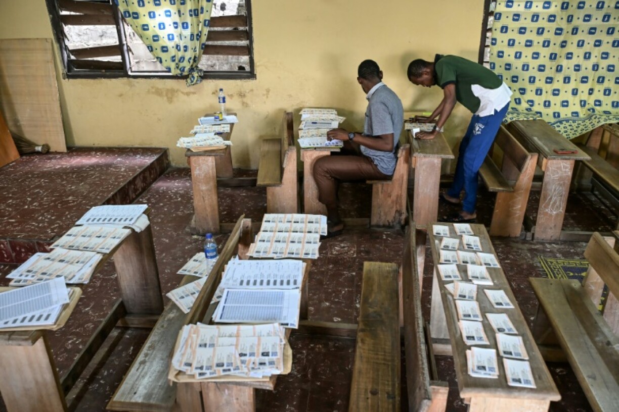 Volunteers prepare to distribute voter cards at an Abidjan polling station as Ouattara chases a fourth term