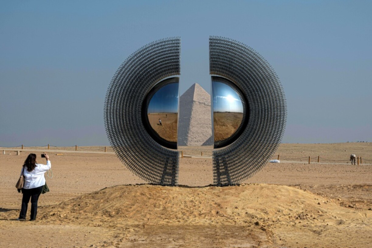 A woman takes a picture of the art installation