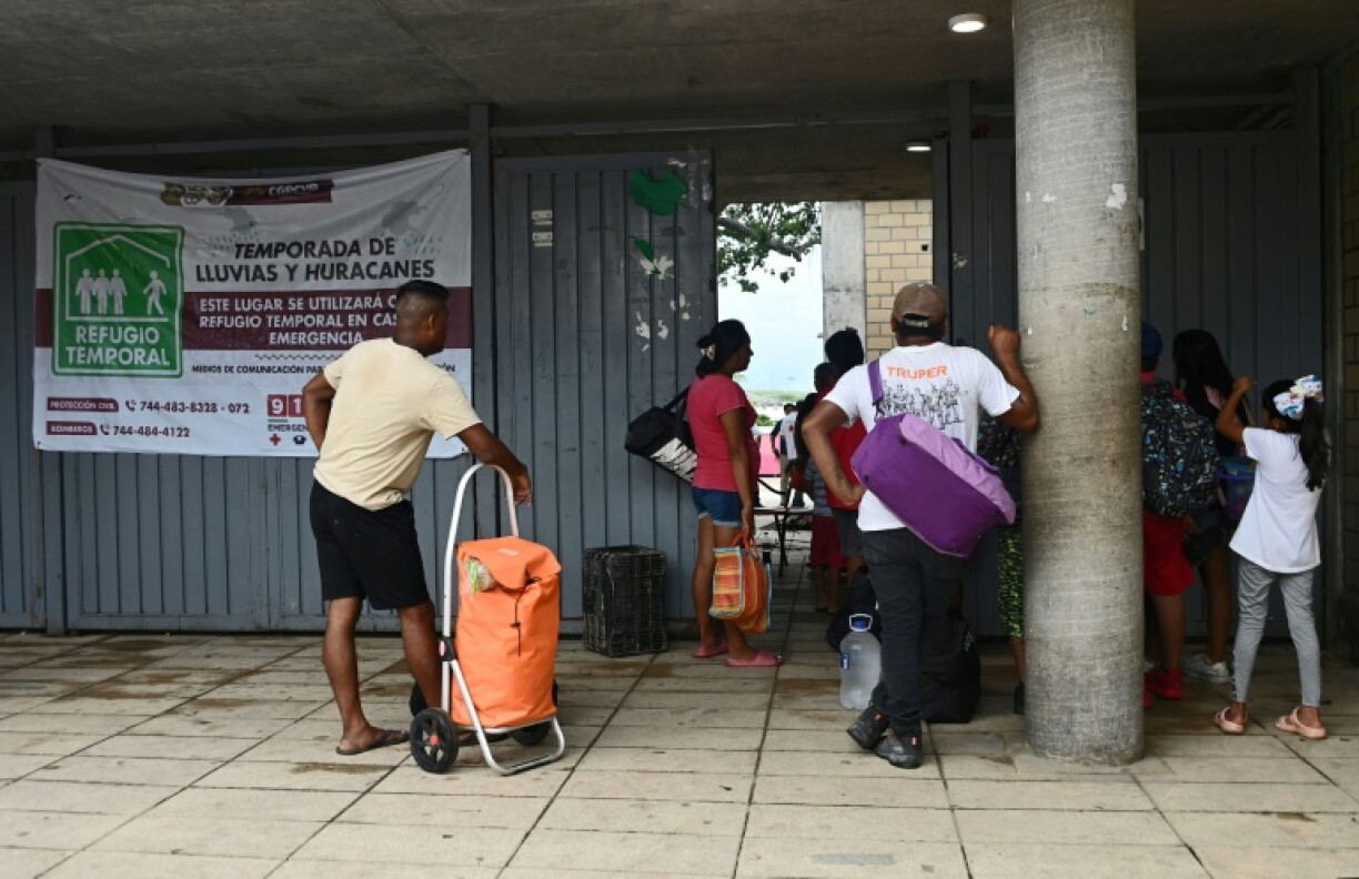 People arrive at a school set up as a temporary shelter before Hurricane Erick hits Guerrero State, Mexico