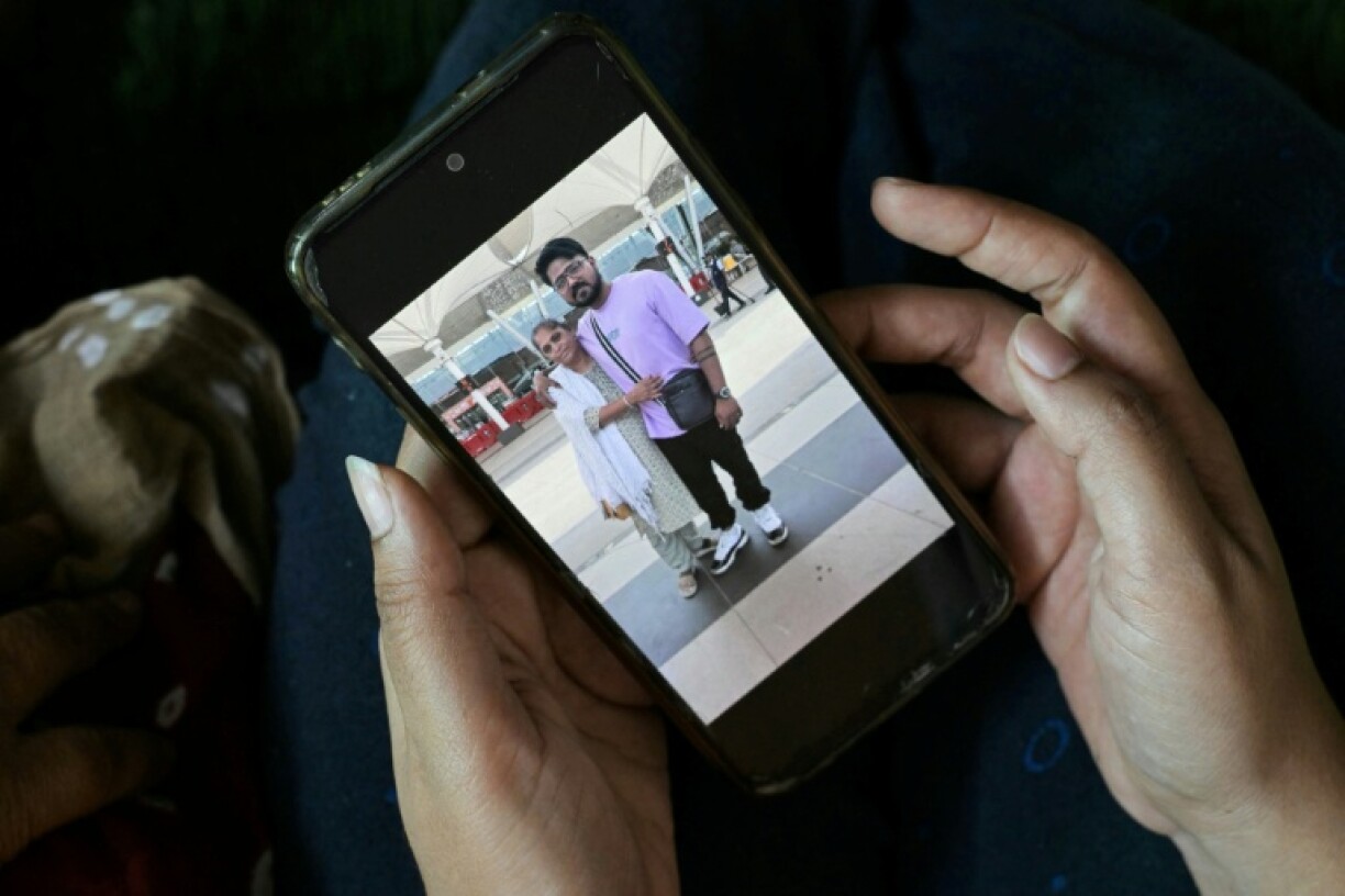 Rinal Christian shows a picture of her late brother Lawrence hugging their mother before he boarded the Air India aircraft
