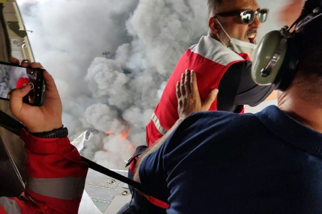 A picture provided by the Iranian Red Crescent shows members of a rescue team arriving by helicopter at the scene of the blast and fire