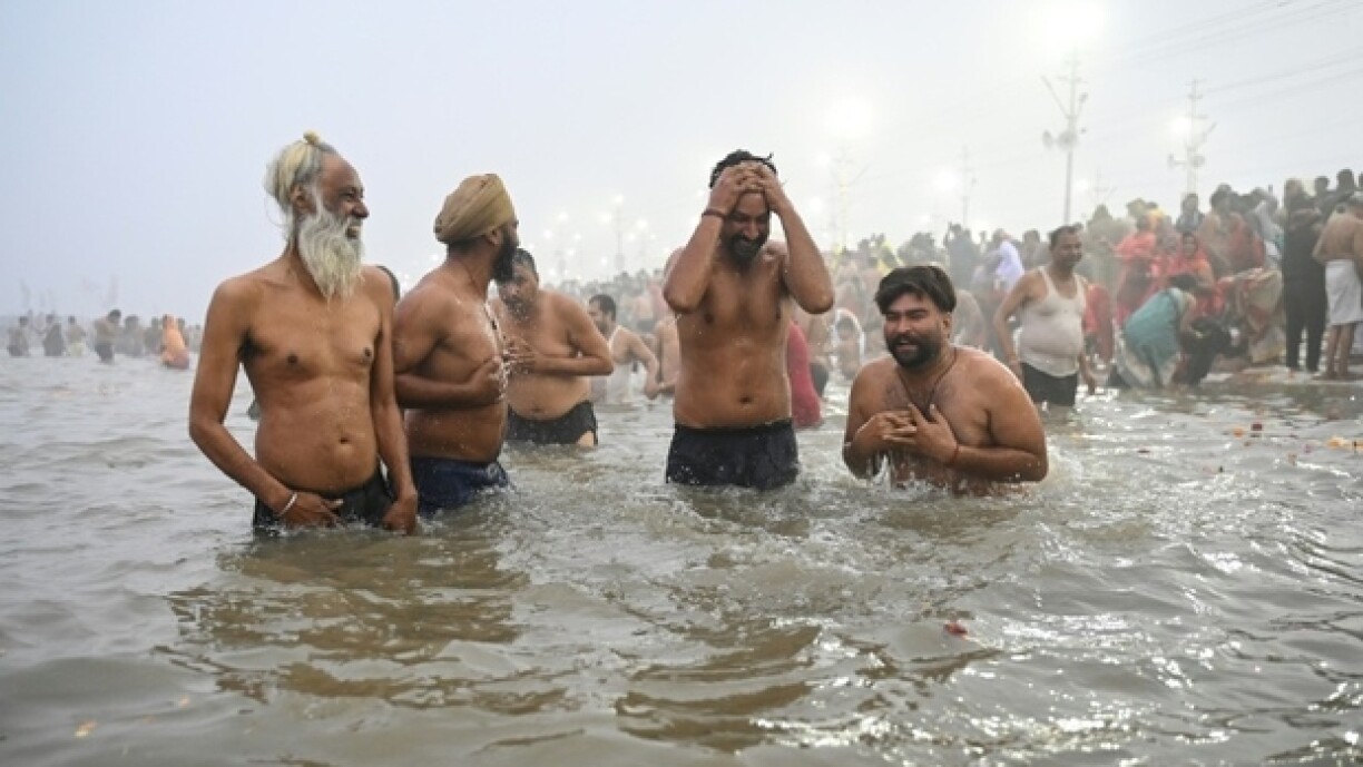 Des pèlerins hindous se baignent dans les eaux froides du confluent des fleuves sacrés du Gange, de la Yamuna et de la Sarasvati à Prayagraj en Inde, le 13 janvier 2025