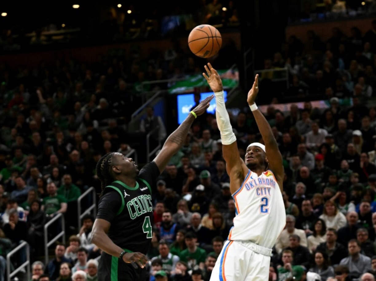 Oklahoma City's Shai Gilgeous-Alexander (right) shoots over Jrue Holiday in the Thunder's win over Boston