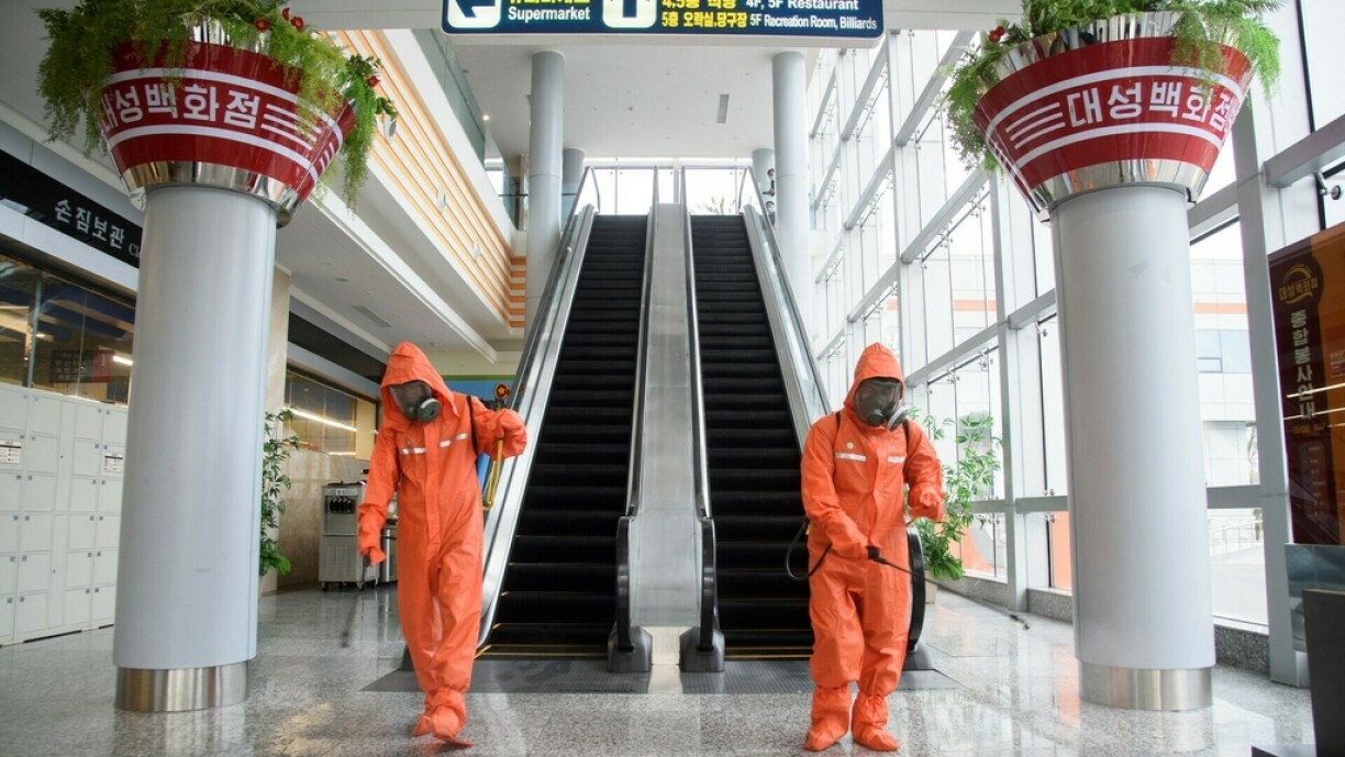 Health officials spray disinfectant as part of preventative measures against Covid-19, in the Daesong Department Store in Pyongyang on September 27, 2021.