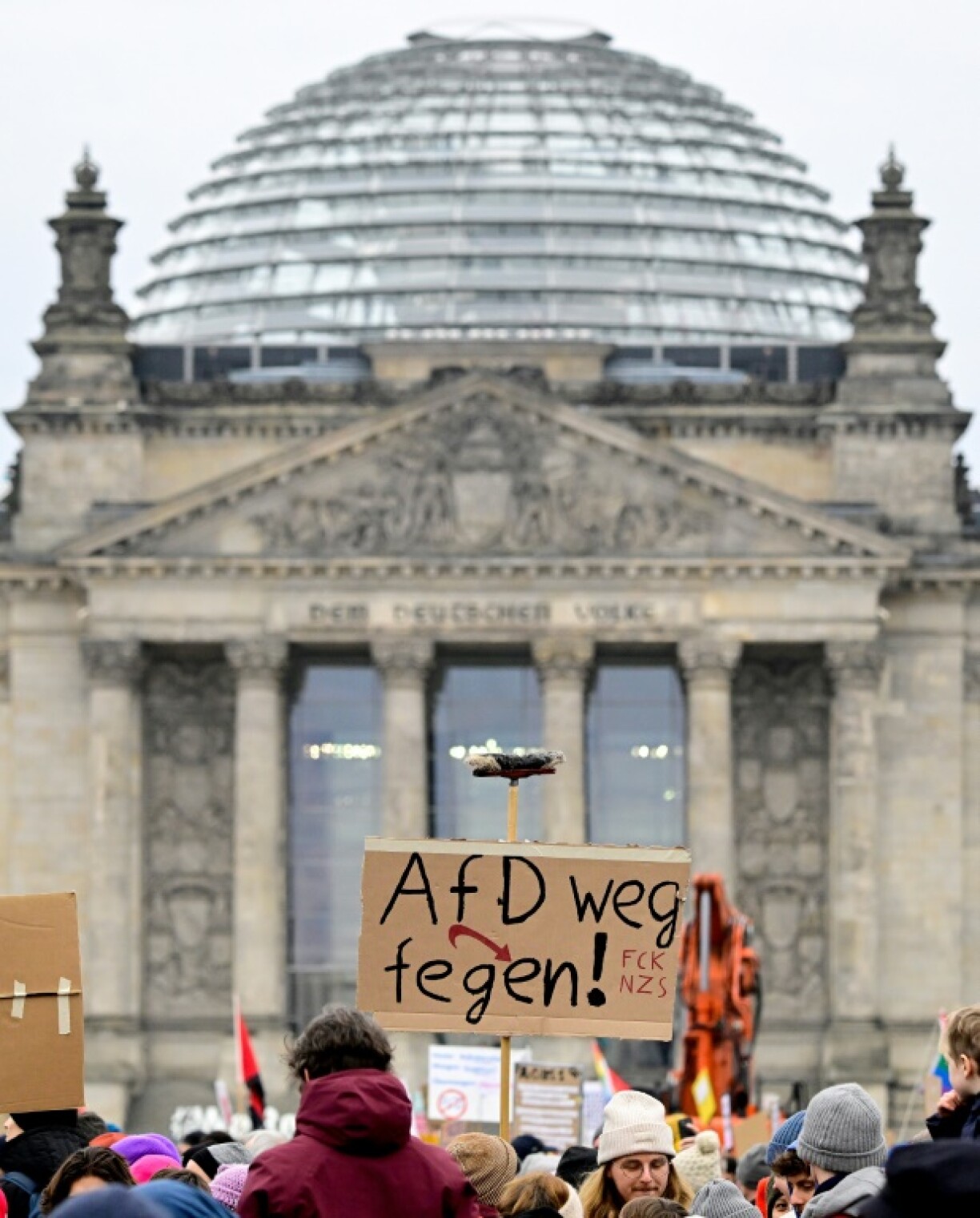 Protesters hold a placard which reads 'Brush away the AfD' in Berlin on February 2, 2025