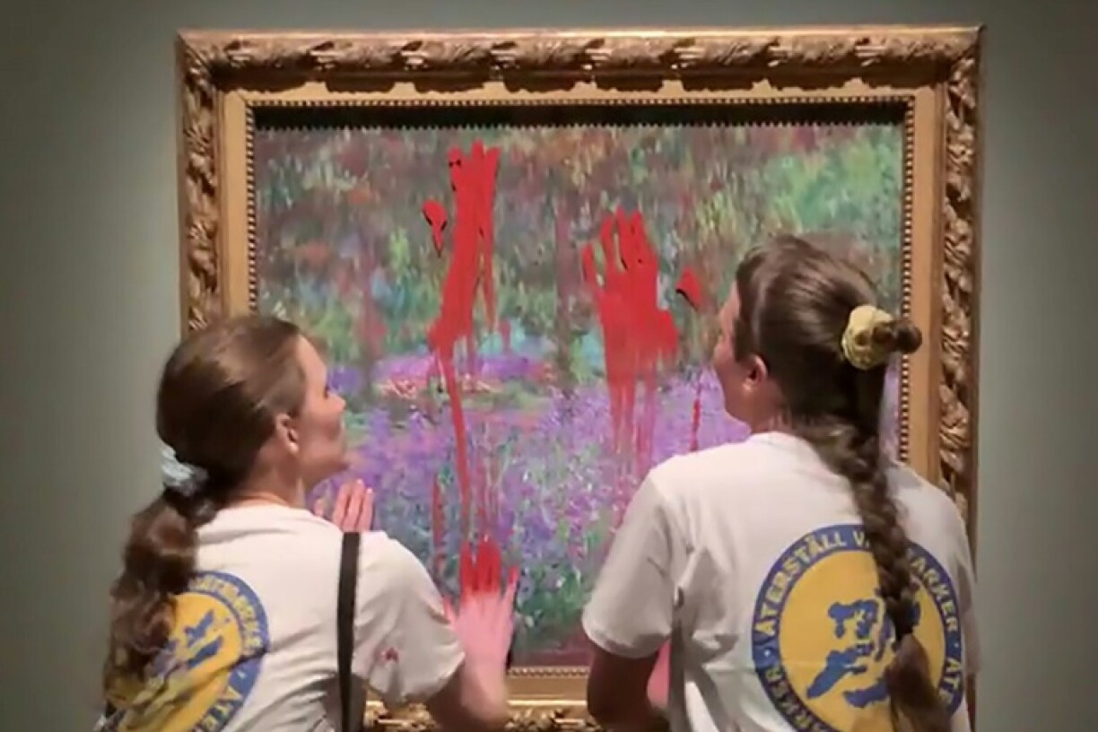 Image tirée d'une vidéo, diffusée le 14 juin 2023 par l'organisation Återställ Våtmarker, de deux militantes écologistes étalant de la peinture rouge sur la vitre protégeant le tableau