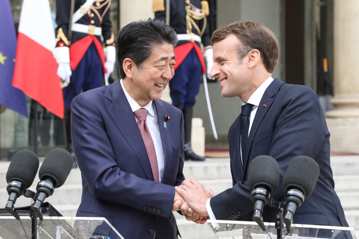 French President Emmanuel Macron (R) and Japanese Prime Minister Shinzo Abe shake hands during a joint press conference at the Elysee Palace in Paris on April 23, 2019.