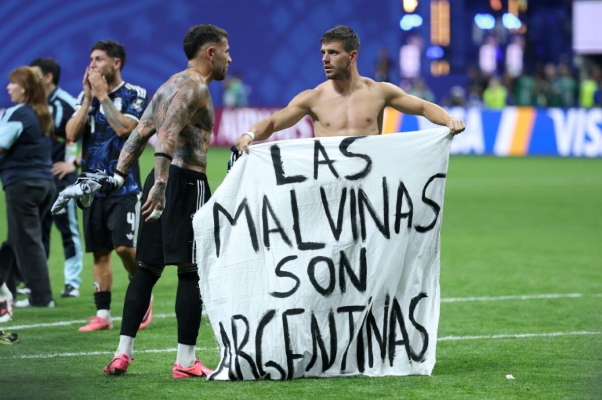Le milieu de terrain argentin Giovani Lo Celso (à droite) et le défenseur Nicolas Otamendi déploient une banderole proclamant: