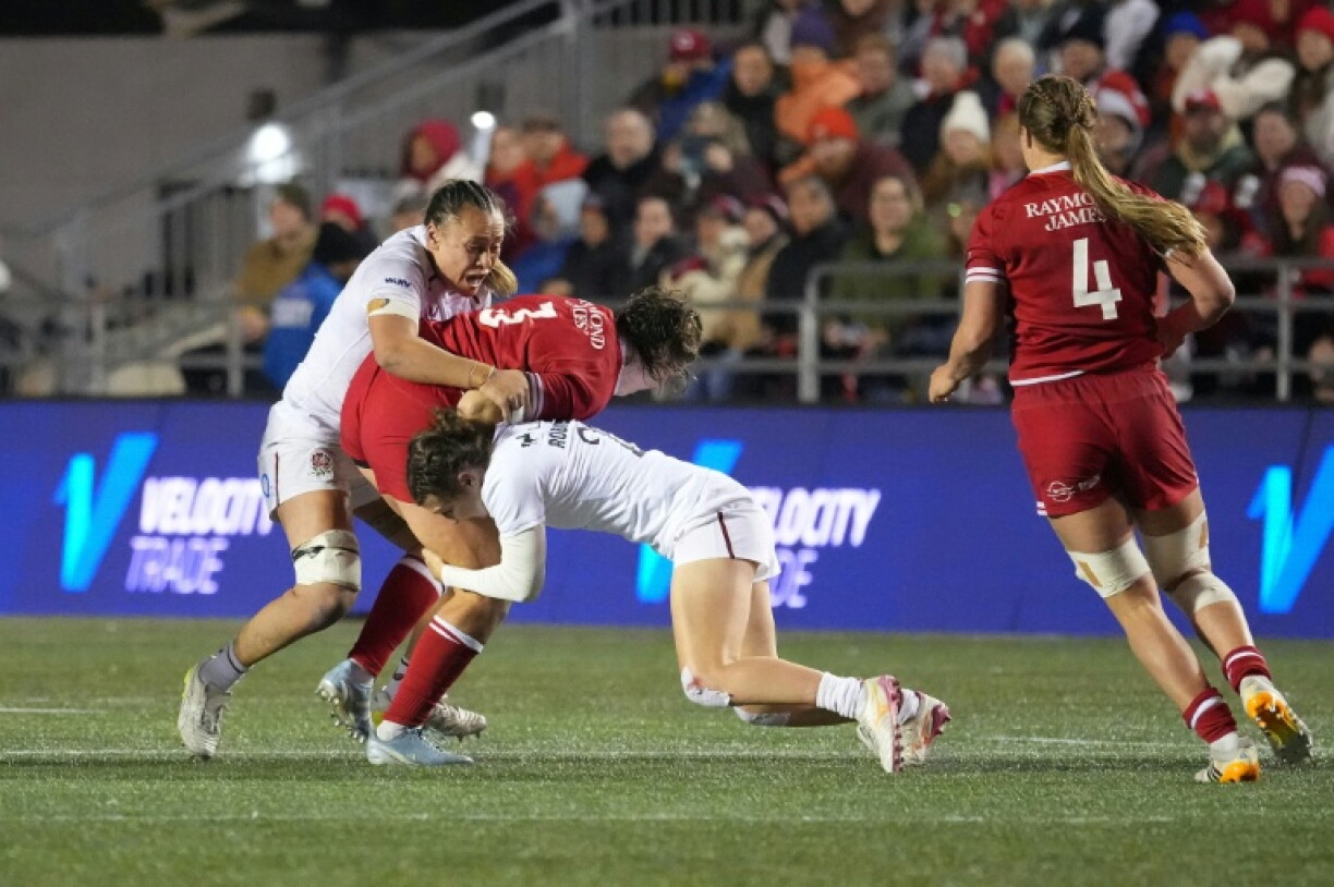 Canada's Daleaka Menin is tackled by England's defence during the Canadians' victory over the world champions