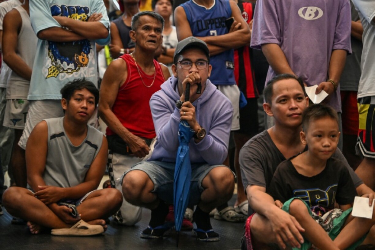 People watch a public screening of the WBC welterweight championship boxing match between Manny Pacquiao and Mario Barrios at Mandaluyong City in Manila