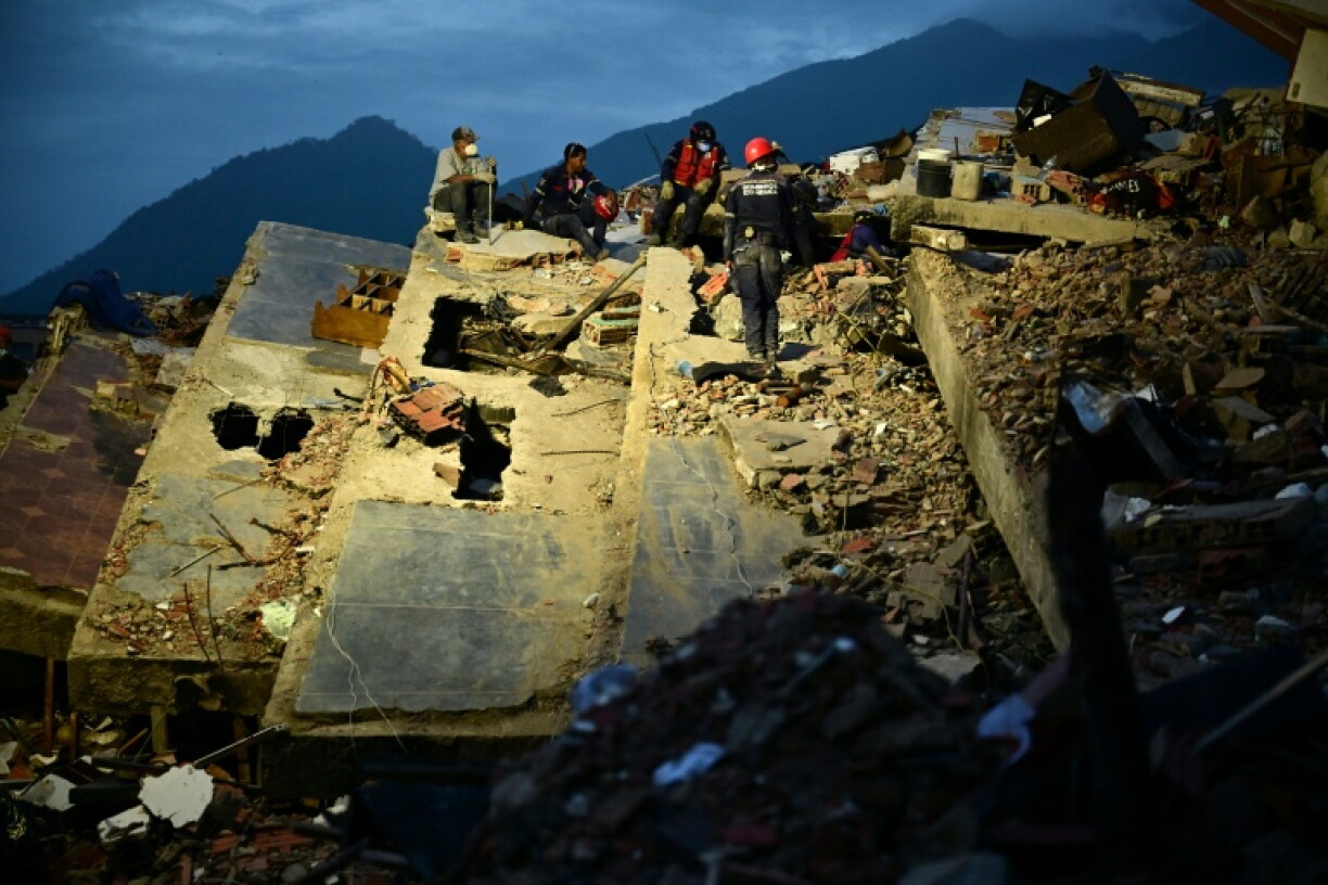 Des secouristes travaillent dans les ruines d'un immeuble effondré après le double séisme au Venezuela, le 3 juillet 2026 à Caraballeda, dans l’État de La Guaira