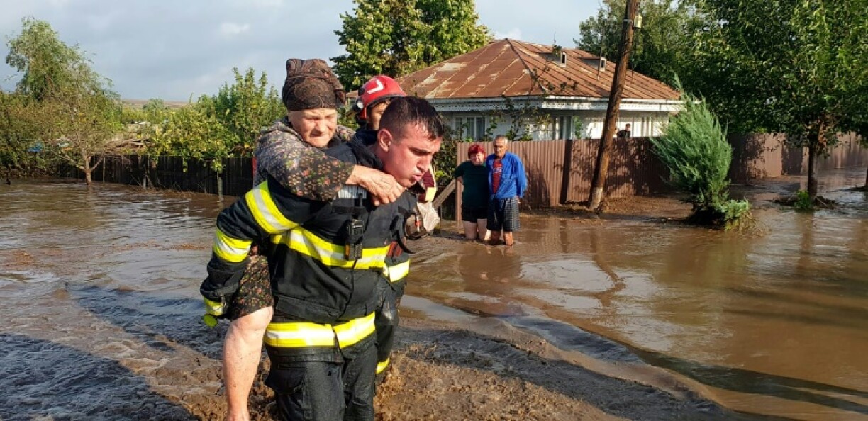 Un secouriste évacue une femme âgée, le 14 septembre 2024, dans le village inondé de Pechea, en Roumanie