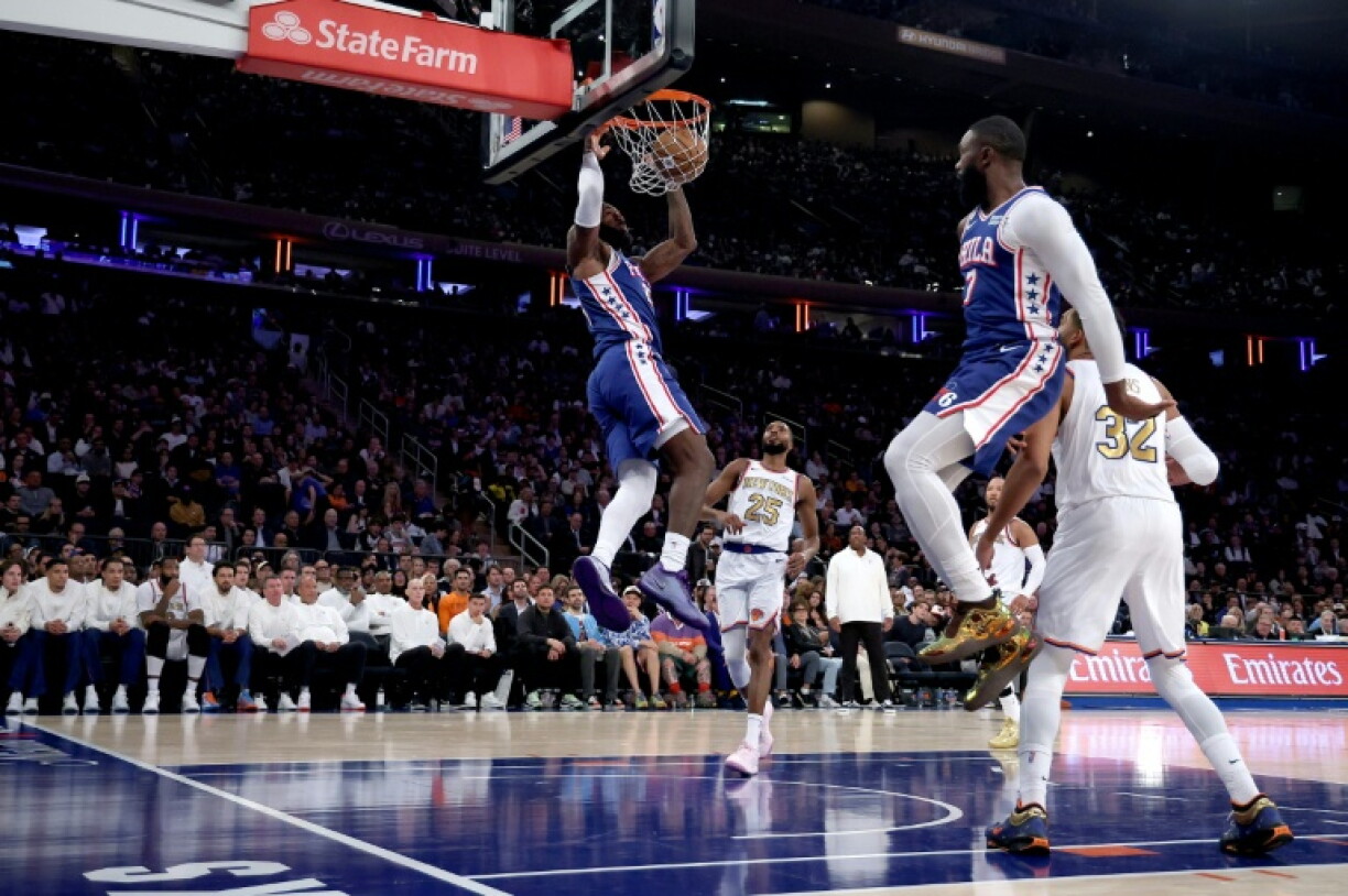 NBA superstar LeBron James throws down a dunk as Phildalphia beat the defending champion New York Knicks in his 76ers debut