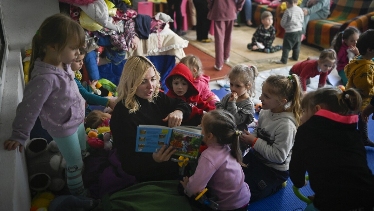 Kanner, déi aus der Ukrain geflücht sinn, kréien an engem Flüchtlingszenter a Bulgarien eng Geschicht gelies.