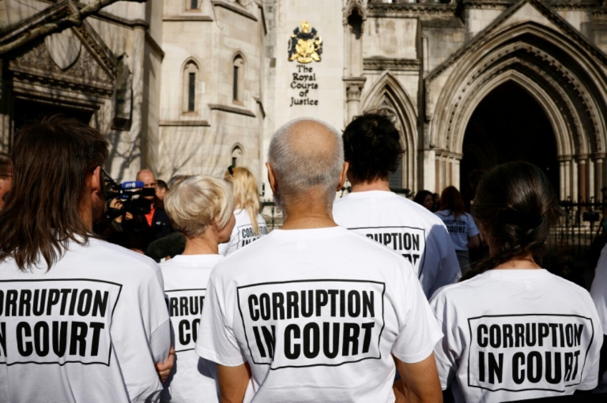 Protesters stand outside the Royal Courts of Justice in central London in support of 16 climate activists who have received jail terms for high-profile protests in their campaign to end the use of fossil fuels