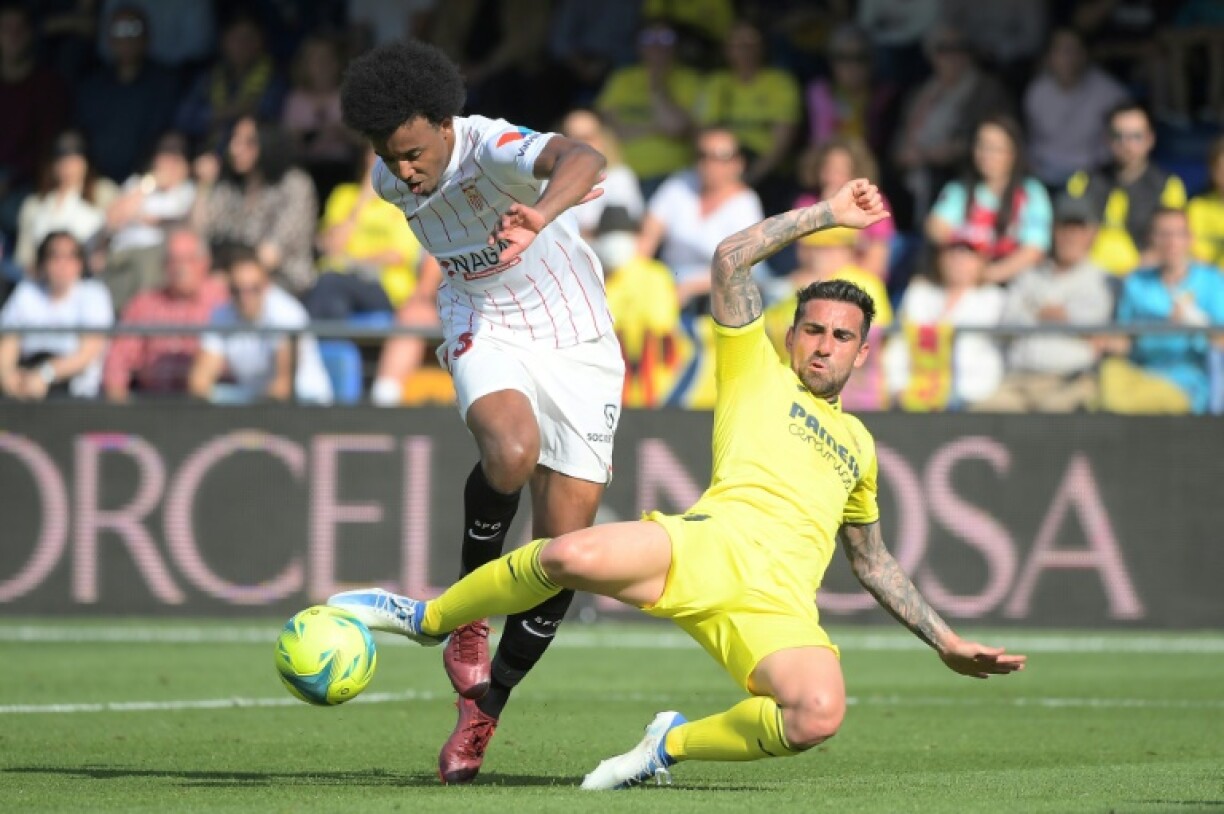 Le défenseur de Séville Jules Koundé (g) taclé par l'attaquant de Villarreal Paco Alcacer, le 8 mai 2022 à Vila-real