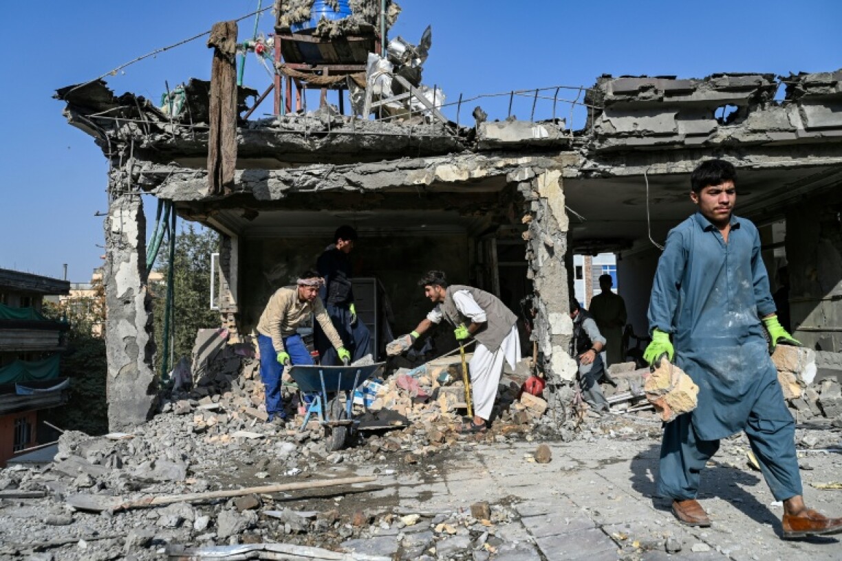 Workers remove debris from a house damaged after a a suspected air strike in Kabul