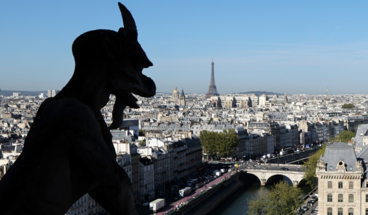Une chimère de la cathédrale Notre-Dame de Paris surplombant la ville, avec la tour Eiffel visible en arrière-plan, lors de l'inauguration du nouveau parcours de visite des tours, le 19 septembre 2025