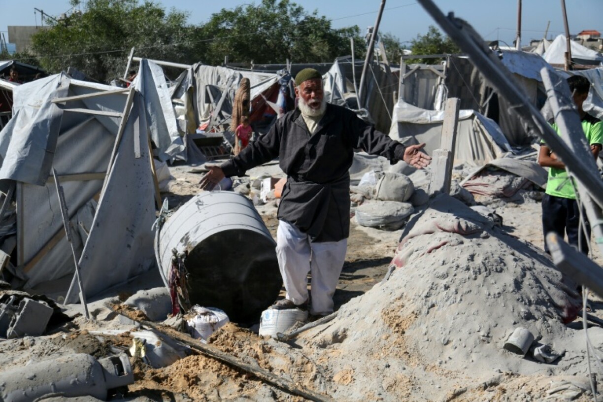 A Palestinian man reacts amid destruction after an Israeli strike at a camp for displaced Palestinians in Khan Yunis, southern Gaza