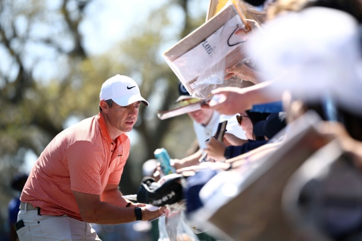Rory McIlroy signs autographs for spectators at The Players Championship, where he took the phone of a heckler during a practice round