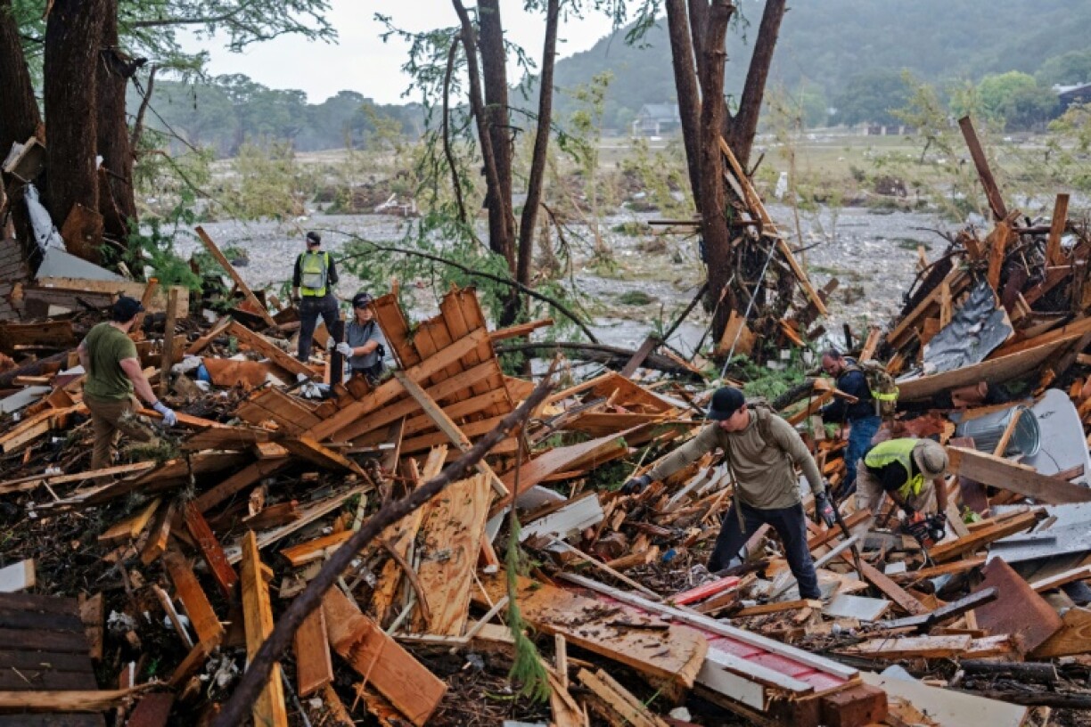 Search and rescue workers dig through debris looking for any survivors or remains of people swept up in the flash flooding