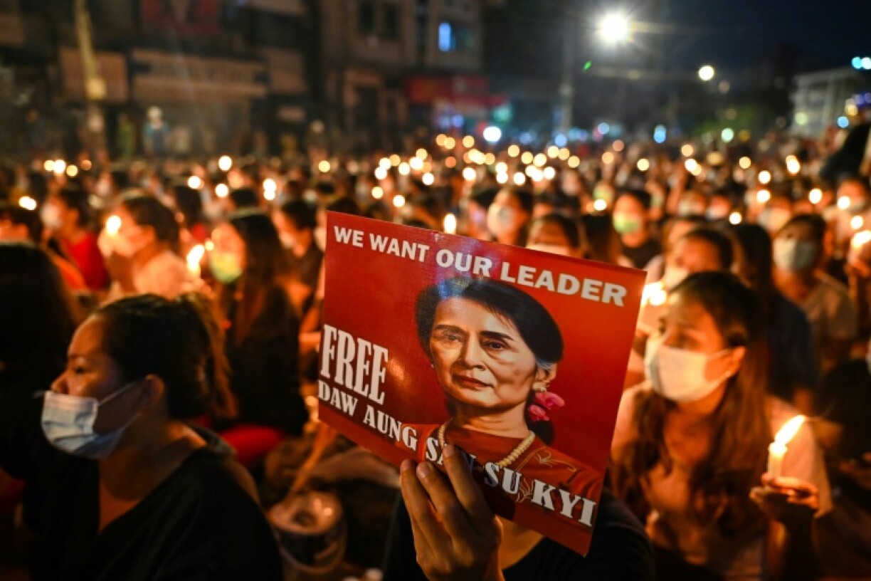 A protester holds a poster of Aung San Suu Kyi during a candlelight vigil to honour those who have died during demonstrations against the military coup in Yangon on March 13, 2021