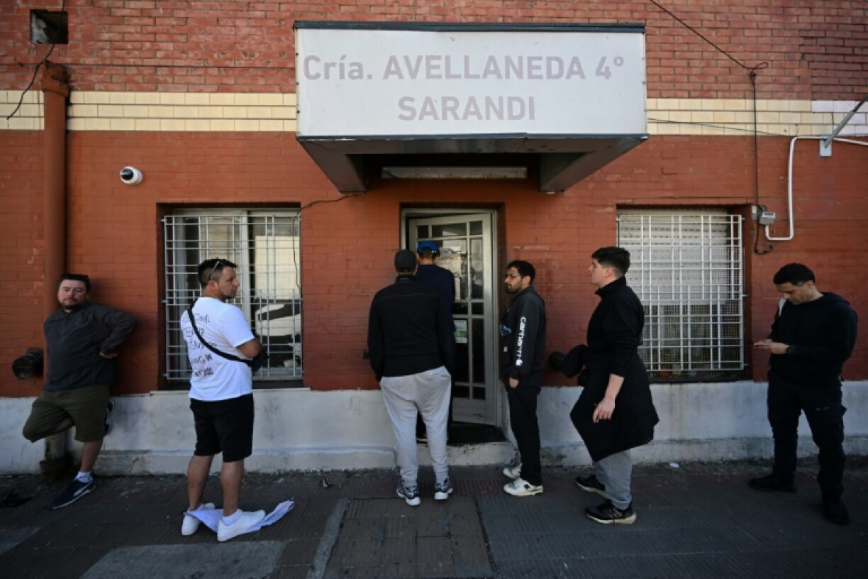 Friends and relatives of the detained fans of Universidad de Chile wait for information outside at a police station