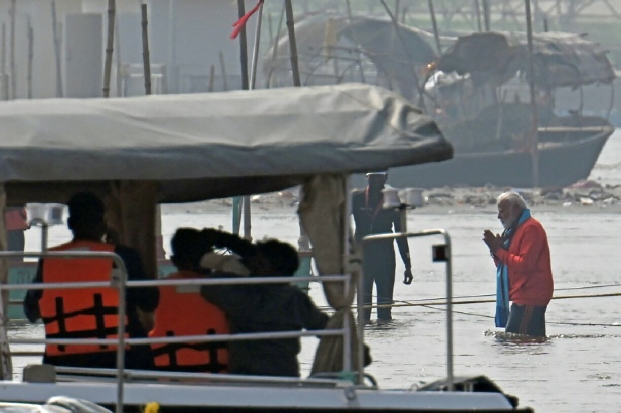 India's Prime Minister Narendra Modi (R) takes a dip in sacred waters at the world's largest religious festival