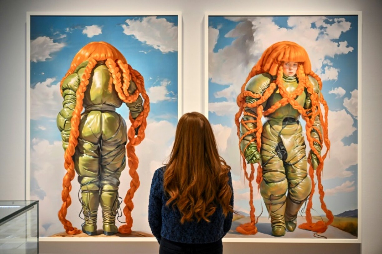 A person looks at AI artwork created by Holly Herndon and Mat Dryhurst called‘Embedding Study 1 & 2 (from the xhairymutantx series)’