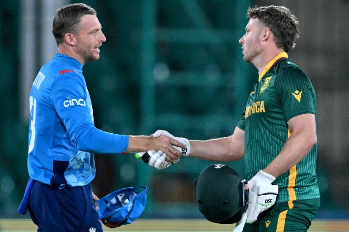 Jos Buttler (L) shakes hands with South Africa's David Miller after England suffered a heavy defeat in his final match as captain