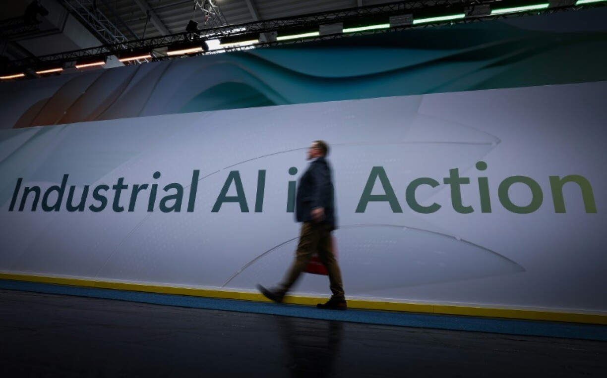 A visitor walks past a sign reading 'Industrial AI in Action' during the opening of the Hannover Messe