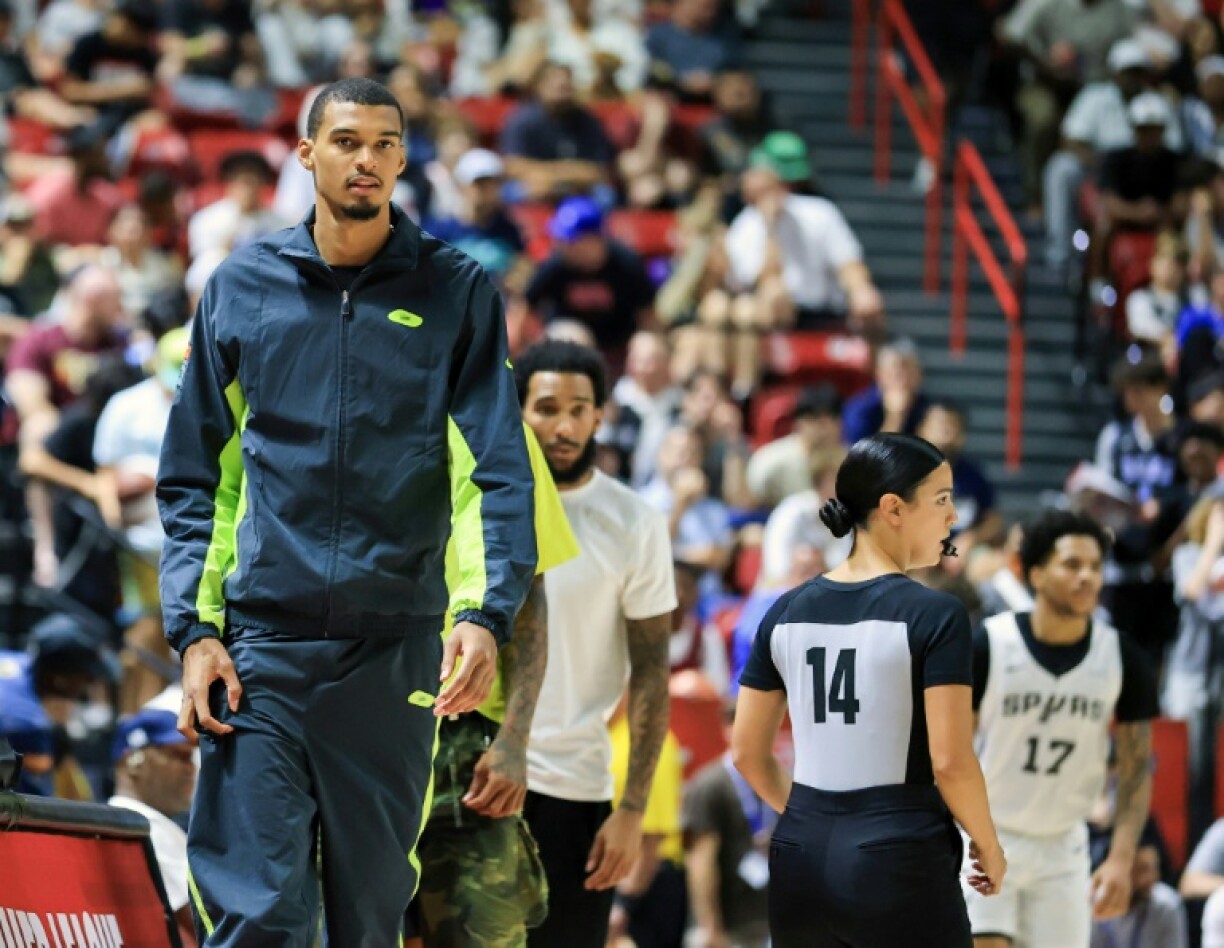 French center Victor Wembanyama of the San Antonio Spurs, at left attending an NBA Summer League game, has been cleared to return to the Spurs after being sidelined last season due to deep vein thrombosis in his right shoulder