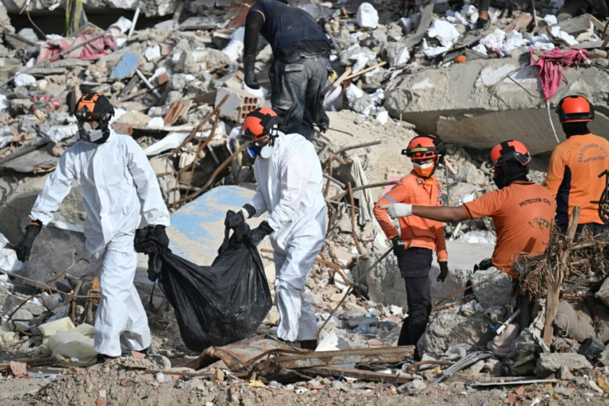 Des secouristes transportent un sac mortuaire à travers les décombres d’un immeuble effondré à Caraballeda, au Venezuela, le 17 juillet 2026, après les séismes du 24 juin.