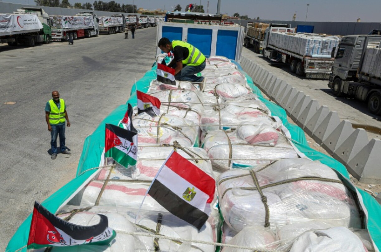 Des bénévoles vérifient des colis tandis que les camions chargés d'aide humanitaire attendent l'autorisation, du côté égyptien au point de passage de Rafah avec la bande de Gaza, d'entrer dans le territoire palestinien assiégé, le 6 août dernier