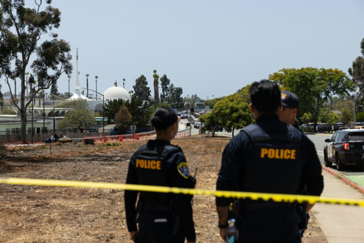 Deux membres des forces de l'ordre près de la mosquée de San Diego, en Californie, où trois personnes ont été tuées et où les deux tireurs présumés ont été retrouvés morts, le 18 mai 2026
