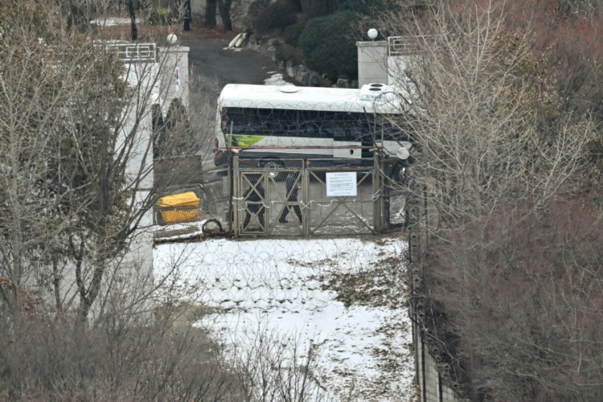 Security personnel check an entrance gate locked to protect impeached South Korean president Yoon Suk Yeol