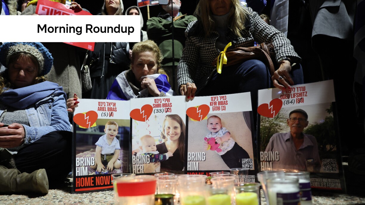 People gather behind posters of four Israeli hostages, hours after four bodies were handed over to Israel by the Palestinian Hamas group, during a candlelight vigil held in their honour at hostage square in Tel Aviv on February 20, 2025.