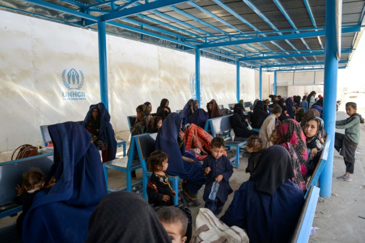 Afghan women and children refugees deported from Pakistan wait inside a UNHCR registration centre at the border crossing