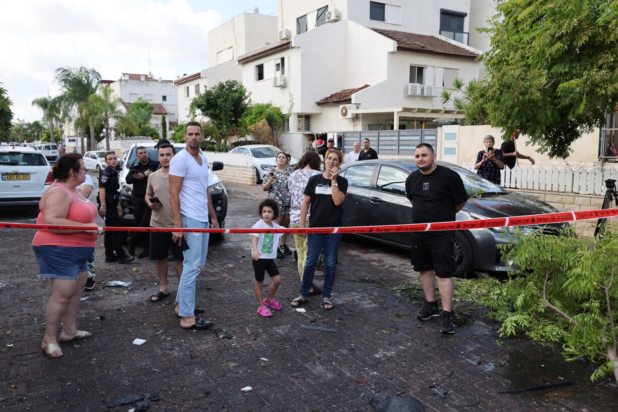 Des habitants se rassemblent derrière une zone bouclée à Kiryat Bialik, dans le district de Haïfa en Israël, ciblée par une frappe signalée du Hezbollah libanais le 22 septembre 2024. Le Hezbollah a déclaré le 22 septembre avoir ciblé des installations de production militaire et une base aérienne près de Haïfa, dans le nord d'Israël, après que l'armée israélienne a pilonné le sud du Liban et a déclaré avoir ciblé des milliers de lance-roquettes.